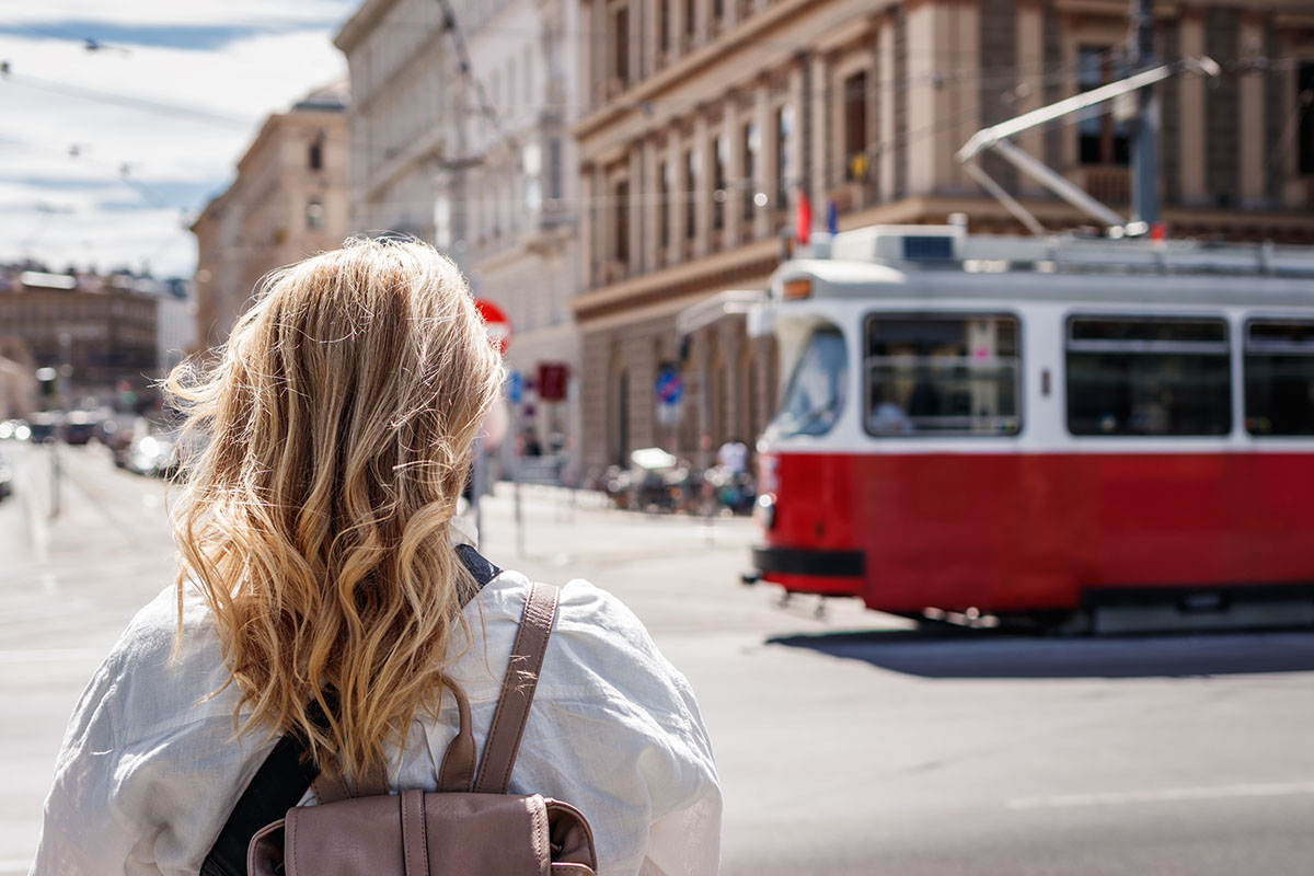Blond woman looking at passing tram in Vienna, Austria