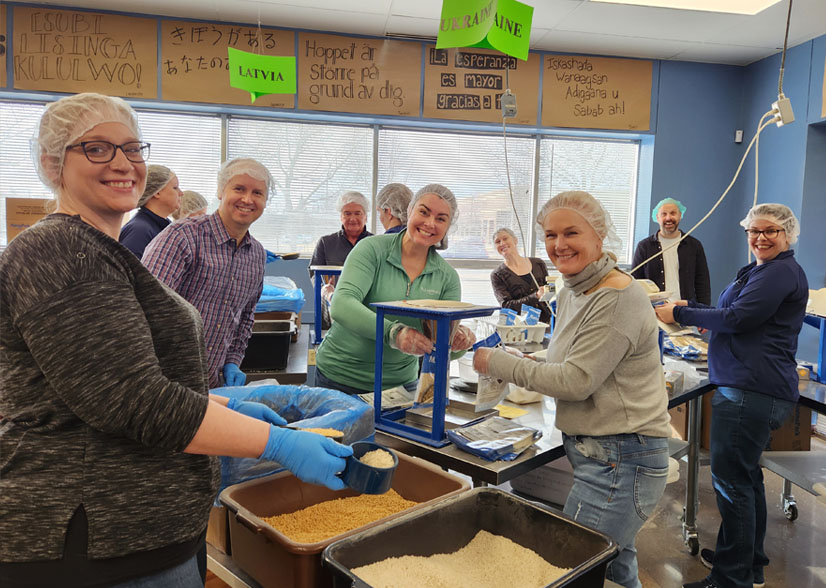 Eleven employees fro Plus Relocation volunteering and packaging food for developing nations